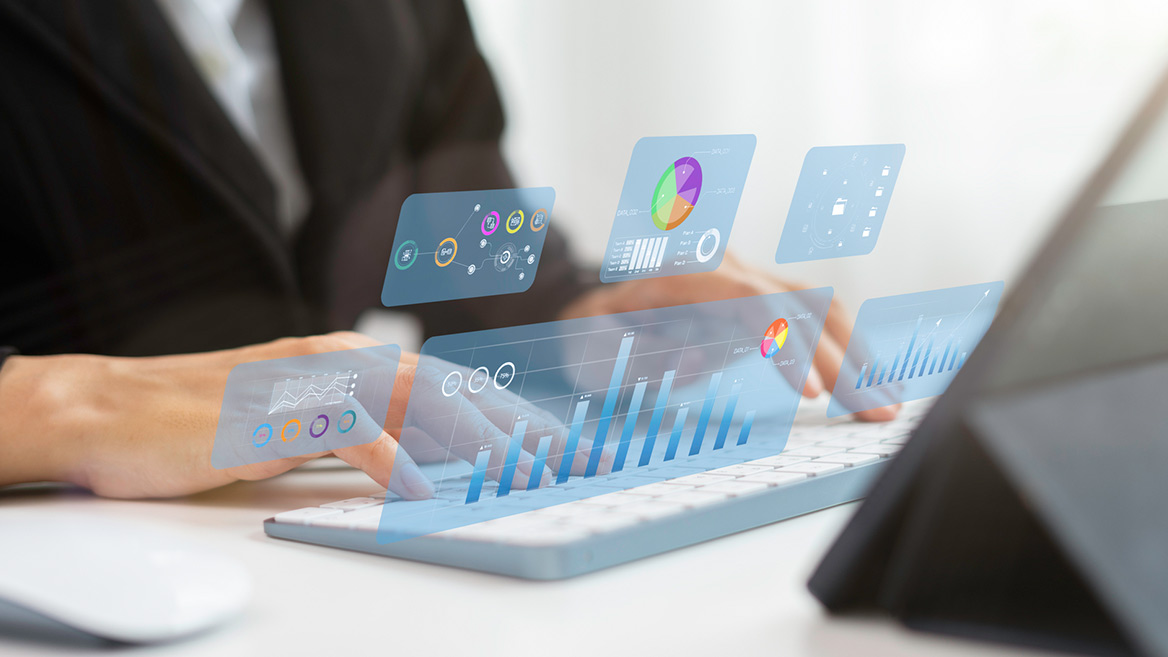 person at computer typing with charts and graphs